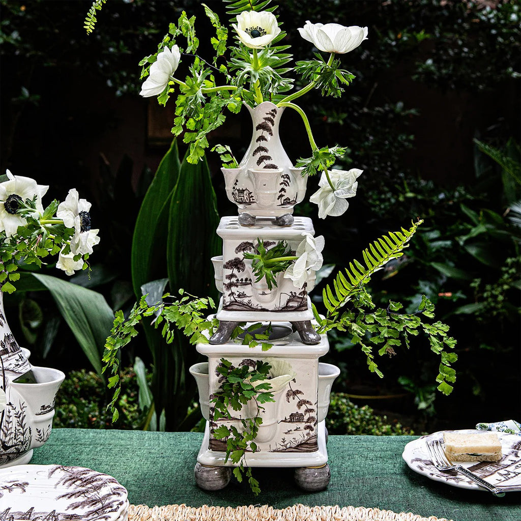Tulipiere tower set in flint grey with three stacked vases, adorned with white flowers and greenery.