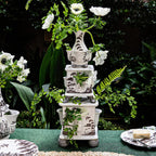 Tulipiere tower set in flint grey with three stacked vases, adorned with white flowers and greenery.