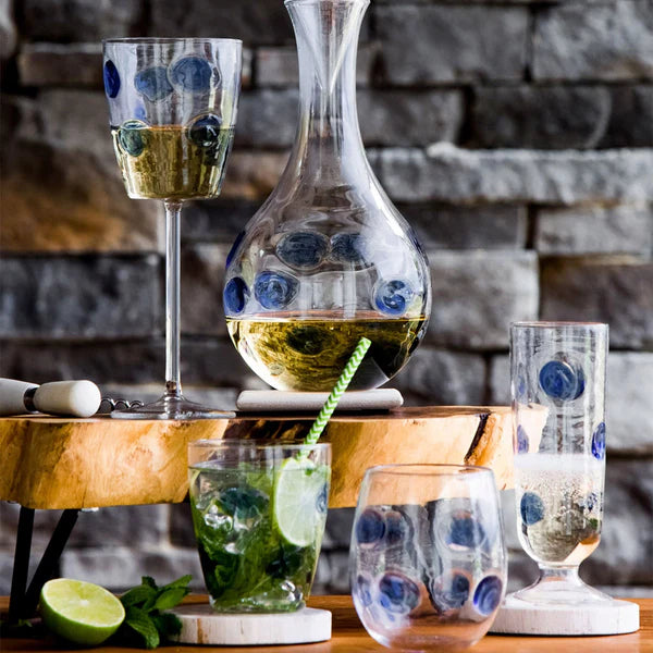 Drop blue stemless wine glass featuring a transparent design with blue dots, placed on a wooden surface.