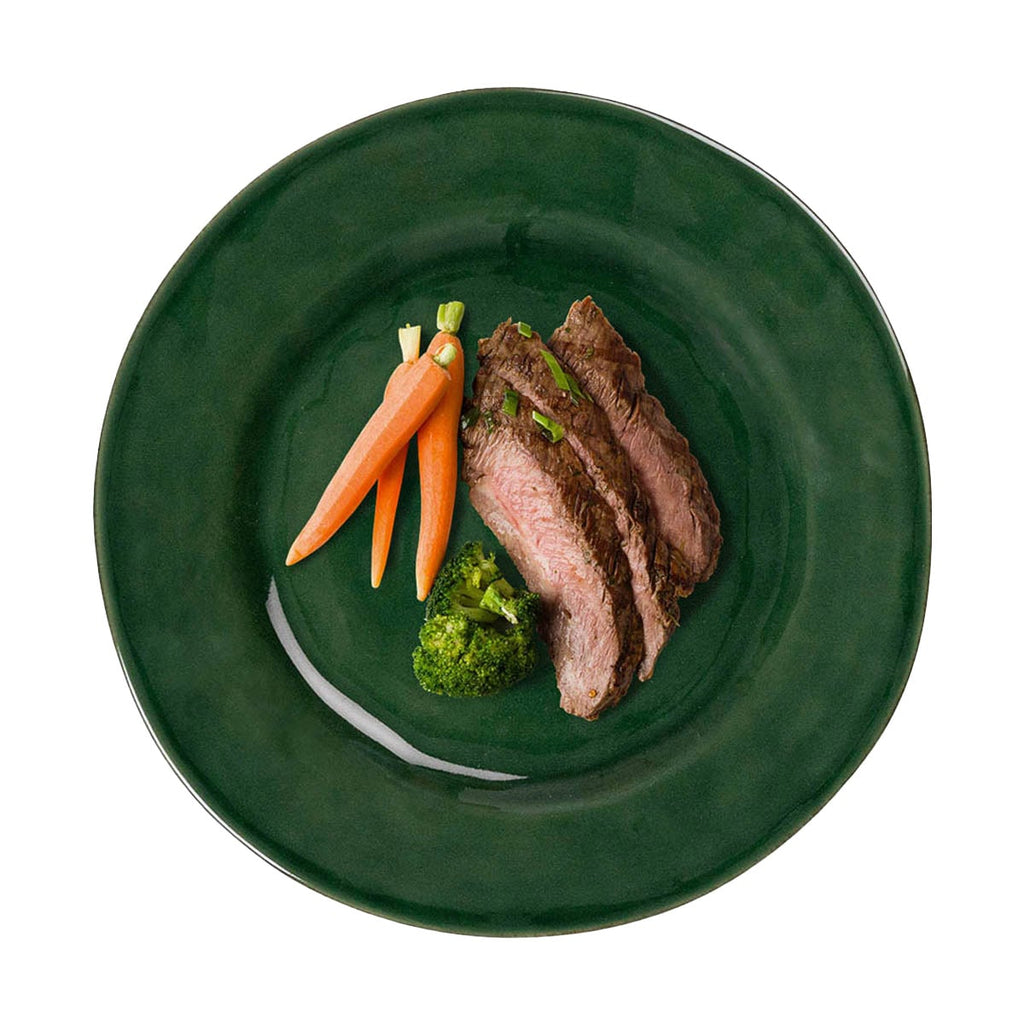 Puro dinner plate in basil green with sliced beef, broccoli, and carrots arranged on a white background.
