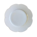 Nymphea white dinner plate with a scalloped edge and smooth surface, viewed from above.