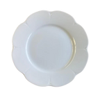 Nymphea white dinner plate with a scalloped edge and smooth surface, viewed from above.