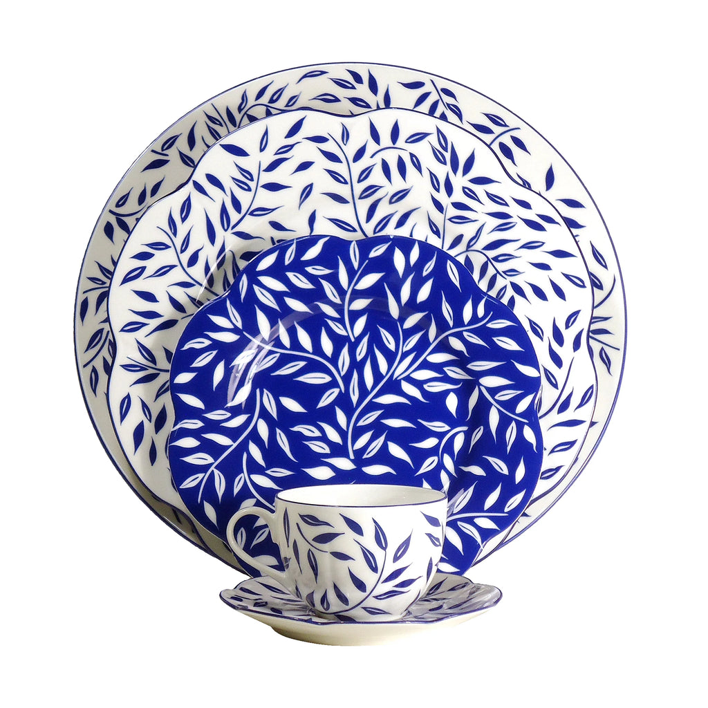 Olivier charger plate in blue featuring a leaf pattern on a white background, displayed with matching dinnerware.