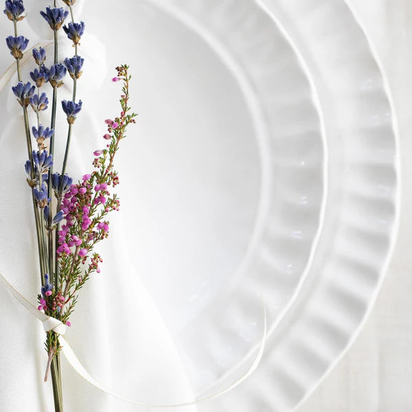 Pietra Serena salad plate with a textured rim, accompanied by dried lavender and pink flowers on a white background.
