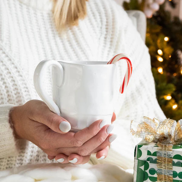 Pietra Serena mug held by a person, featuring a white ceramic design and a red and white candy cane.