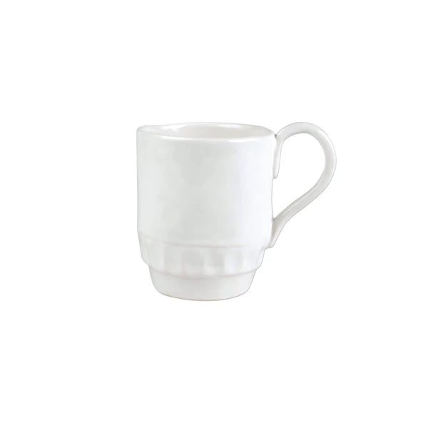 Pietra Serena mug in white ceramic with a textured base and curved handle, positioned at an angle.