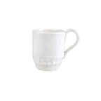 Pietra Serena mug in white ceramic with a textured base and curved handle, positioned at an angle.