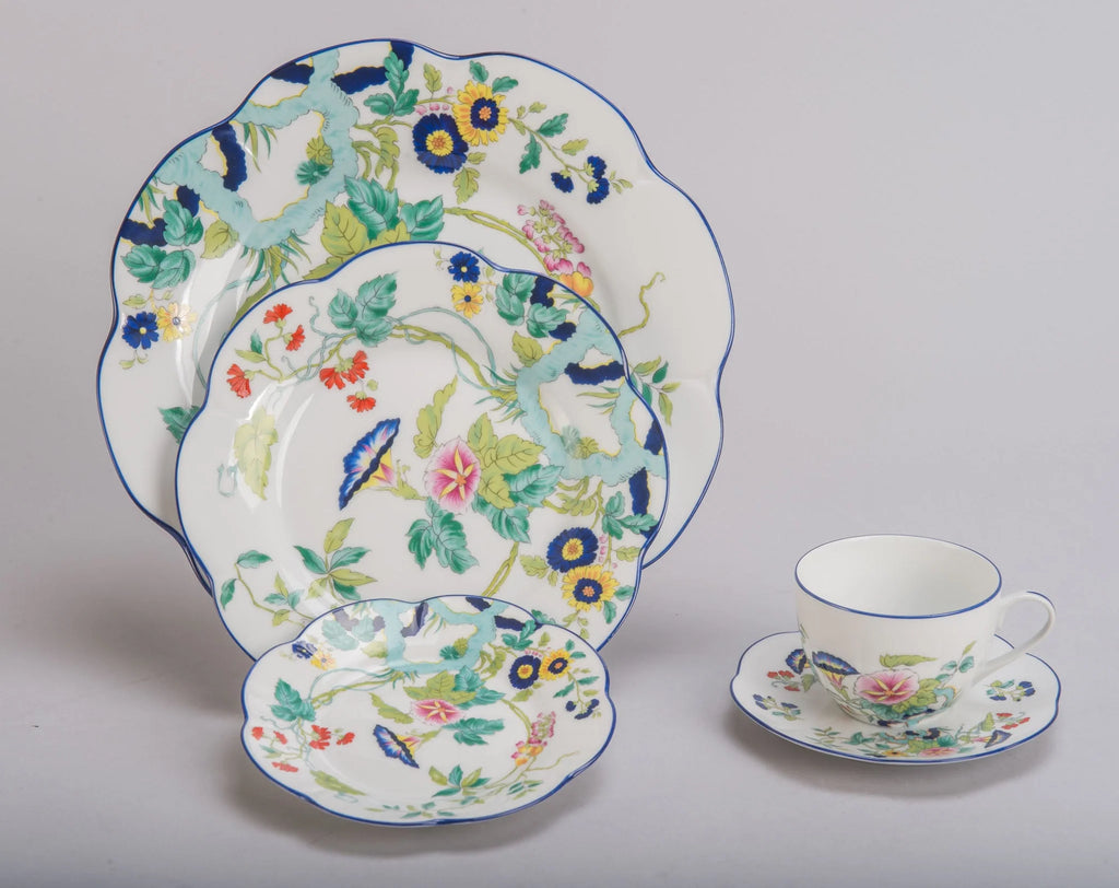 Paradis Bleu dinner plate featuring floral patterns in blue, yellow, and red on a white background with a scalloped edge.